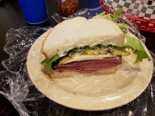 Pastrami Sandwich with provolone cheese, pickles, sprouts and lettuce.