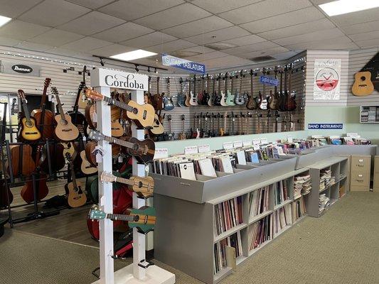 Inside: Cordoba ukuleles, lots of music sheets and guitars