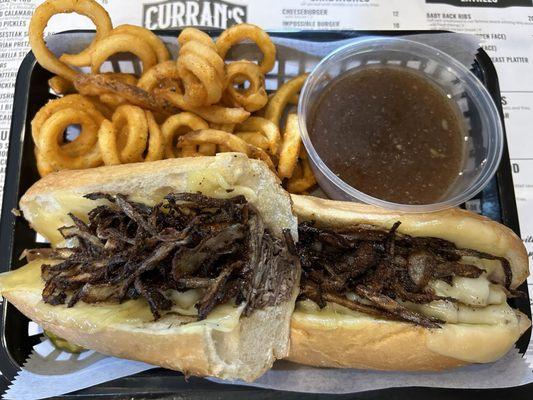 French Dip Sandwich with curly fries - Swiss cheese, crispy onion strings and homemade roast beef. Au jus and horseradish.