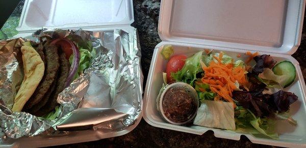 Lamb gyro (without tatziki sauce) with Greek salad for take out. Delicious lamb and salad.