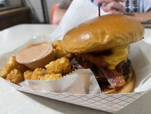 Scrumptious Western bacon cheeseburger with crispy tots and fry sauce