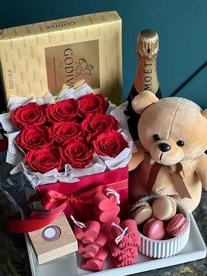 Gift set with forever roses, chocolates, champagne, candles, teddy bear and fragrance oil