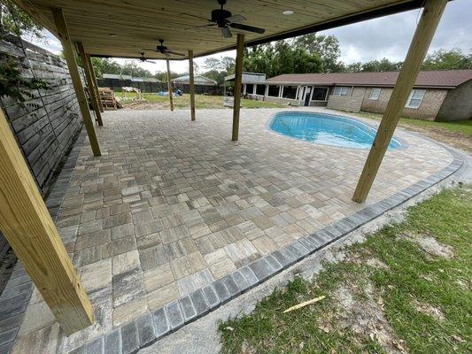 Belgard Napoli grand cobble pool deck with charcoal pool coping and boarder accent.