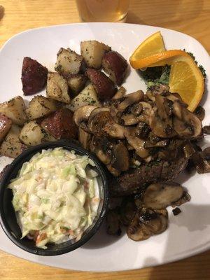 A 8 oz . grilled sirloin steak with mushrooms. Baby Reds and coleslaw