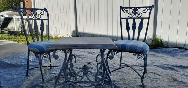 Patio bistro iron chairs with padded seat iron table with solid wood top with blue grey distressed color sceam