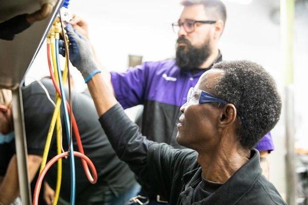 HVAC students working in lab with instructor guidance.