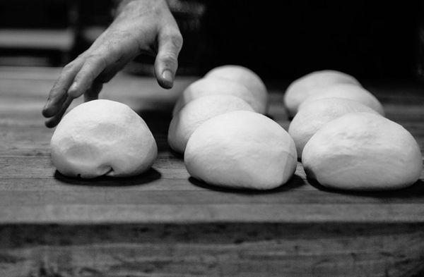 Skilled pizza chefs at work, dividing our scratch-made dough.