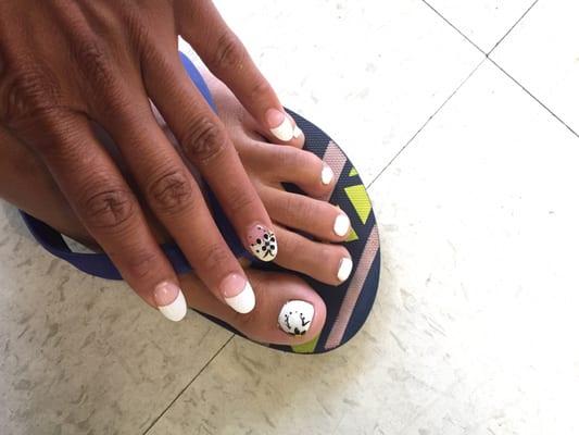 Toes: White gel polish with a flower. Hand: Oval shape French tip with a creative little flower on the ringer fingers