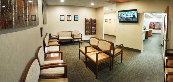 Large comfortable waiting room with a TV and updated magazines.