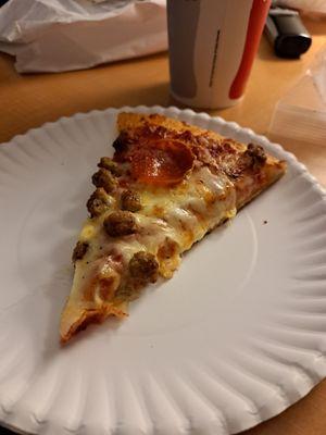 Slice from a large two topping pizza. Sausage and pepperoni on a pan crust dough.