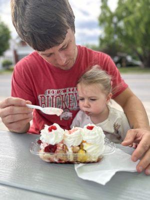 My daughter demolishing a banana split with dad