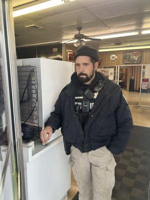 Sheriff that spits tobacco in a cup while standing guard.