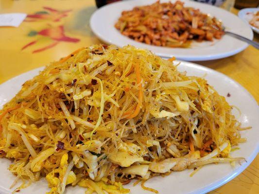 Singapore fried rice noodle with chicken and pork. Chicken and garlic dish in the background.