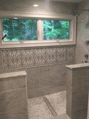 Carrara Natural marble with an amazing Waterjet Marble design that gives this shower the WOW factor