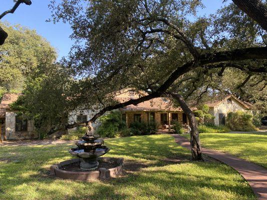 A view of the main building with a glimpse at one of our large oak trees.