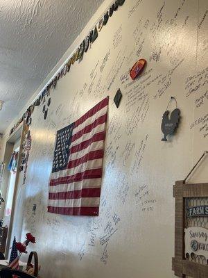 Military patches along with Veterans' autographs on the wall