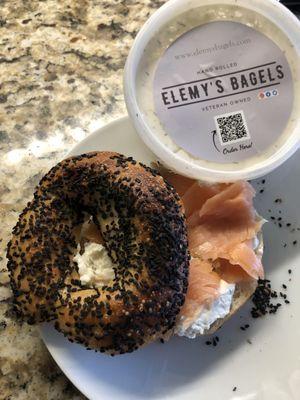 Black sesame bagel with lox cream cheese and lox .