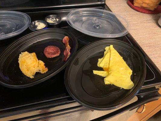 Hash brown casserole, a sausage patty, a single lame slice of bacon, and scrambled eggs.