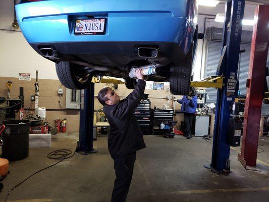 Crist (Manager/technician) installing customers exhaust on a Dodge challenger.