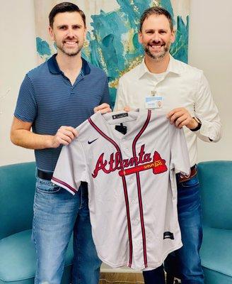 Owners David Milby and William Milby celebrate the Braves win with a new jersey for a super fan/super client!!