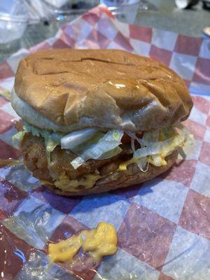 Chicken sandwich with cheese, tomato and lettuce.