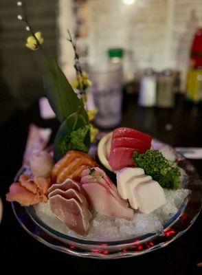 Chefs choice sashimi served with fake flowers and no wasabi.