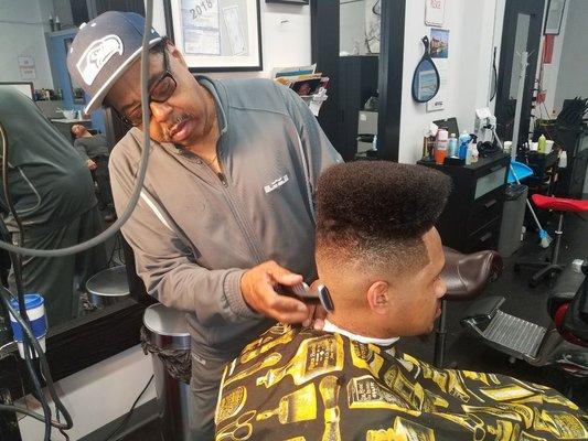 Frank perfecting a high top fade on a regular client.