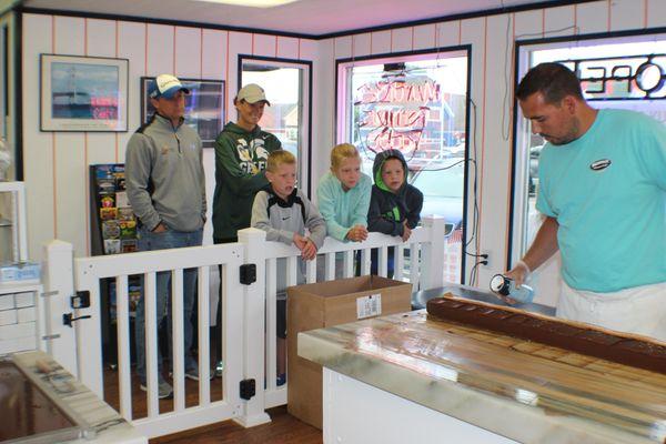 Aaron Murdick making fudge with people in store watching.