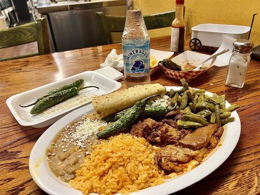 Combination plate, chicharrón en red salsa, nopales, refried beans and rice