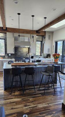 Custom kitchen cabinets, live edge bar top, and custom ceiling beams.