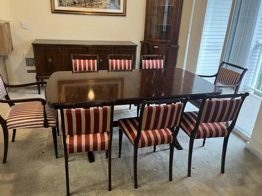 Extended matching mahogany dinning room table and eight chairs, two with armrests. Chair upholstery new condition.