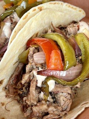 BRISKET TACO chopped brisket, chipotle crema and sauteed onions & peppers on a flour tortilla