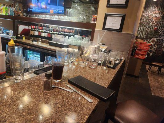 The customer seating area with 60+ dirty  glasses and 1/2 drunk soda.