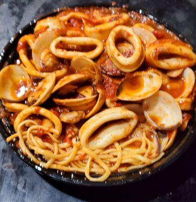 Sautéed Calamari And Clams Over Linguine take-out. Really tasty sauce at La Scala. You wind up scooping it up with a spoon.