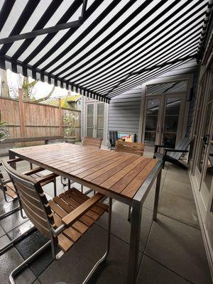 Retractable patio awning. Provides sun protection as well as mild rain protection. Rolled in with the touch of a button