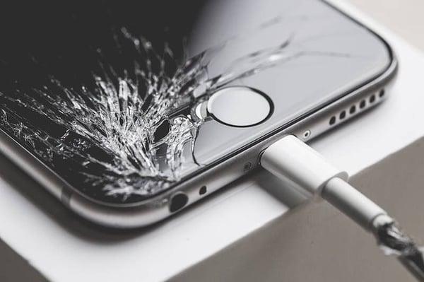 Cracked screen on a iPhone 6 - plus a torn charger cord. Device EMS can replace your screen in under an hour.