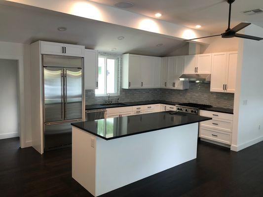 Custom kitchen cabinets, black Silestone, mosaic stone backsplash.