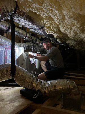 Ebens Air Conditioning Technician in the attic working on the Air Handler.