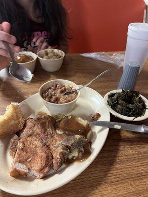 Pork chop, pintos, cornbread, greens, mashed potatoes with brown gravy.