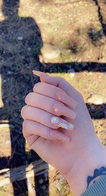 Simple pink coffin nails with daisy in ring finger