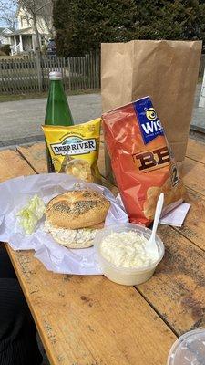 Chicken salad on a roll, chips and coleslaw