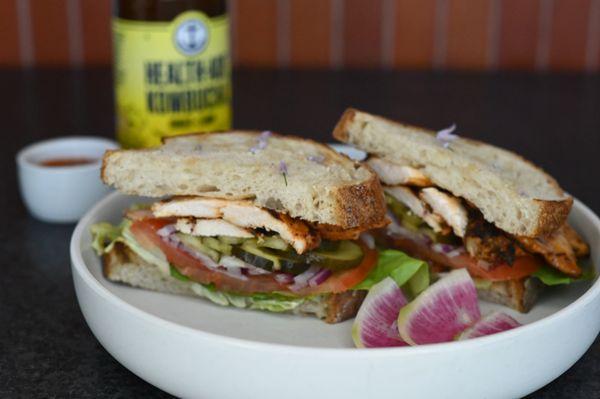 Grilled Chicken Sandwich with lettuce, tomato, onion and pickles on Firebrand Rustic Sourdough. Served with house made chips.