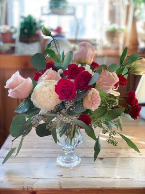 Garden style arrangement featuring peony and peach roses.