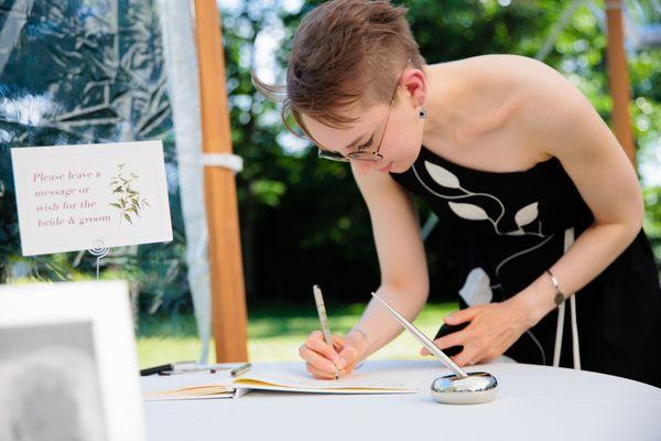 guest book set up with a little sign and pens, next to some family photos! Allison did a great job laying it all out!