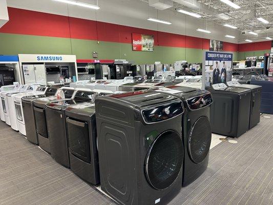 Washer and dryer appliances displayed on the appliance section showroom floor