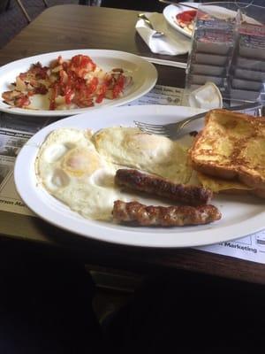 Eggs sausage French toast and home fries.