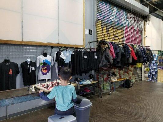 Merchandise and coat hanging area. Chessboard can entertain while you wait for the next class to begin.