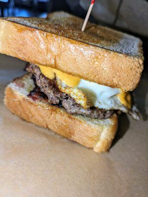 Rise and Shine - 
 Local grass fed beef, fried egg, sliced avocado, bacon, and sriracha mayo on Texas Toast