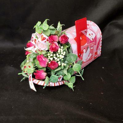 A beautiful silk arrangement poppinh out of a mail box ready for Valentine's. This can also be done in fresh upon request