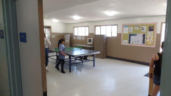 Kids play table tennis (ping-pong) or foosball, grab some snacks or check out equipment from the desk.